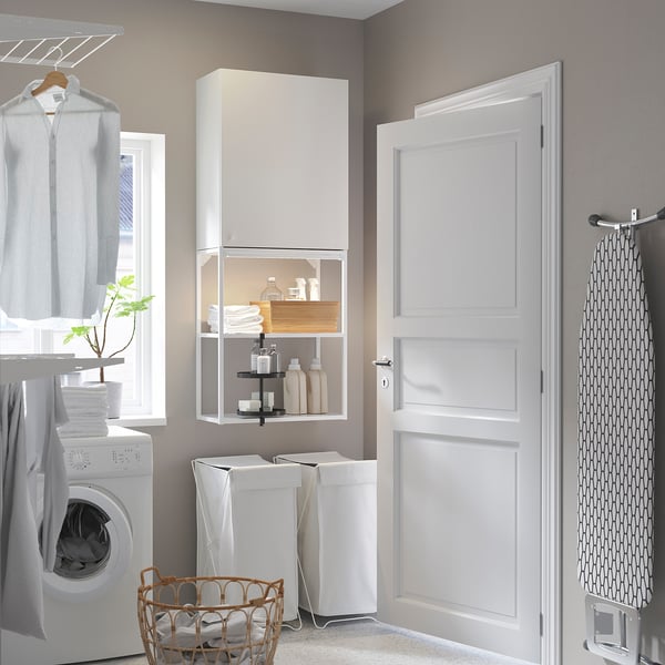 Modern laundry room with white ENHET wall cabinet and open shelves, featuring storage baskets, laundry supplies, and washing machine.