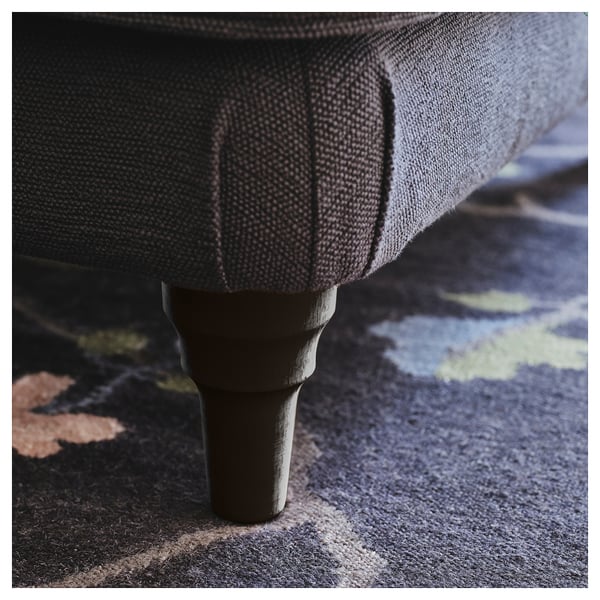 Close-up of a sturdy, polished wooden sofa leg in a rich brown finish, reflecting quality craftsmanship.