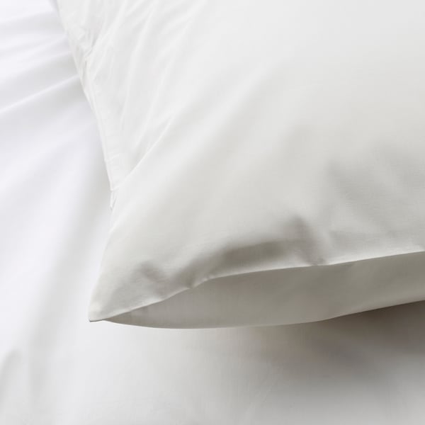 Close-up of crisp, white cotton pillowcase, smooth texture.