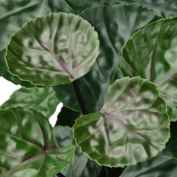 Close-up of lifelike artificial plant leaves, vivid green with detailed, wavy patterns and realistic textures.