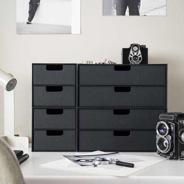 Modern desk organized with FJÄDERHARV black mini chests and vintage cameras.