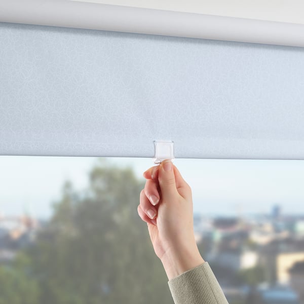 Hand lifting light-blocking roller blind with pattern.