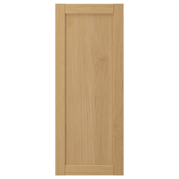 A FORSBACKA wooden door in light brown with a framed design. It oak veneer and a classic bevelled edge style.