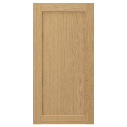 A FORSBACKA cabinet door in warm oak veneer featuring a classic, framed design with bevelled edges.