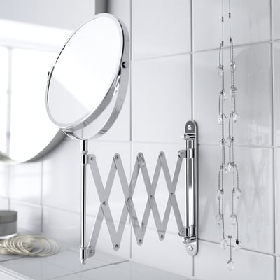 Magnifying mirror on wall with extendable arm for close-up tasks. Built for bathroom use, water-resistant.