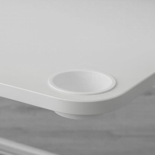 Circular cup holder on desks edge, for convenient access to drinks.