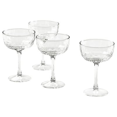Four champagne coupes with faceted designs and long stems.