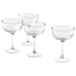 Four champagne coupes with faceted designs and long stems.