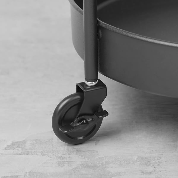 Black metal trolley wheel with swivel and brake, mounted on a stylish bathroom storage unit.