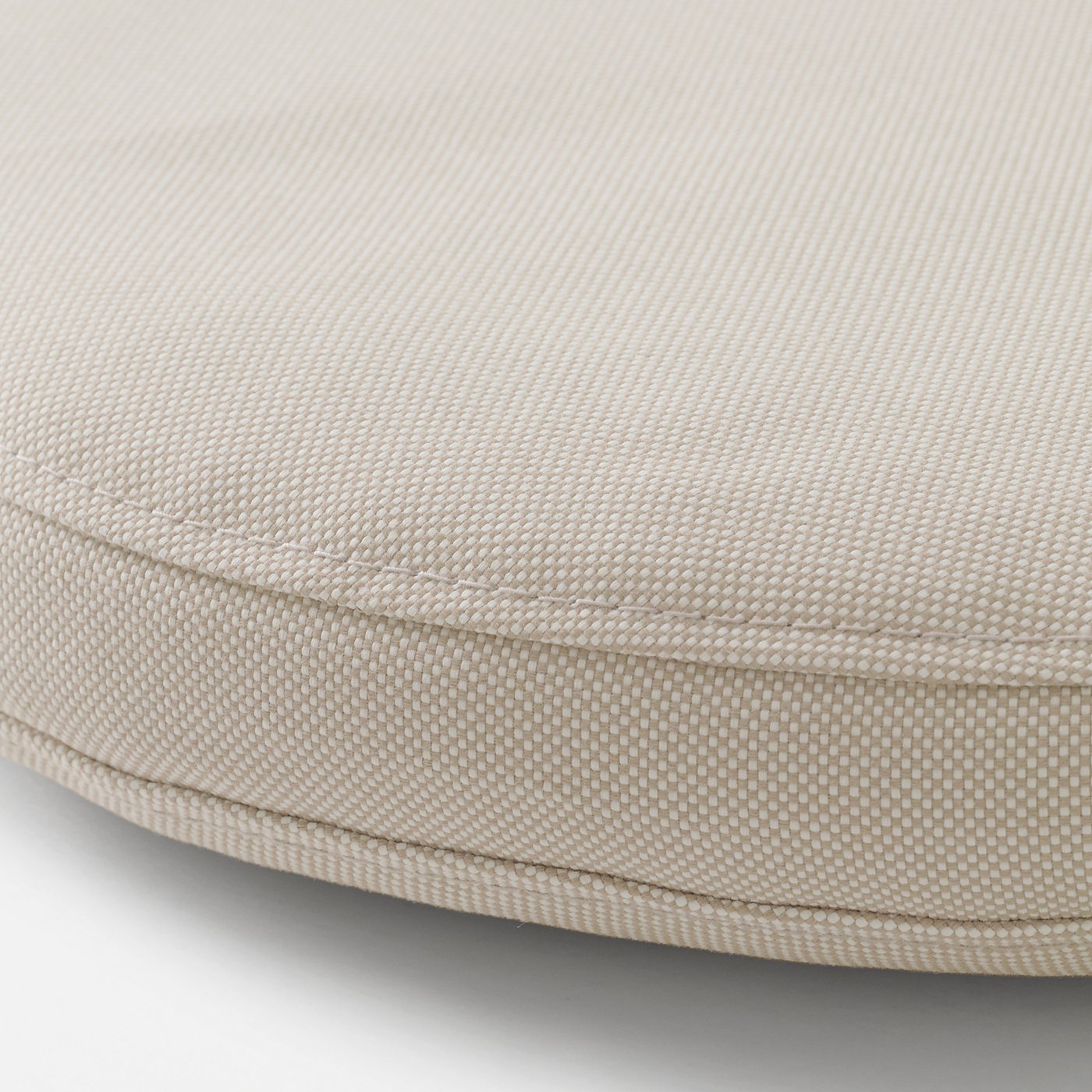 Close-up of light-colored, textured outdoor cushion cover, showing detailed stitching and quality fabric.