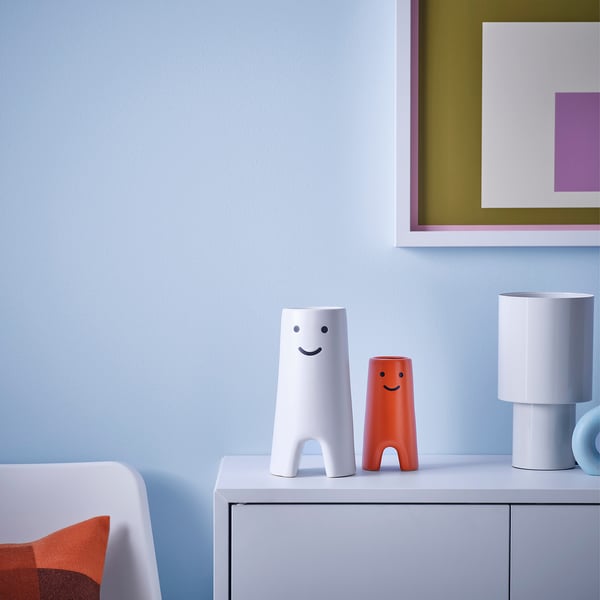 Whimsical vases on shelf with lamp & pillow.