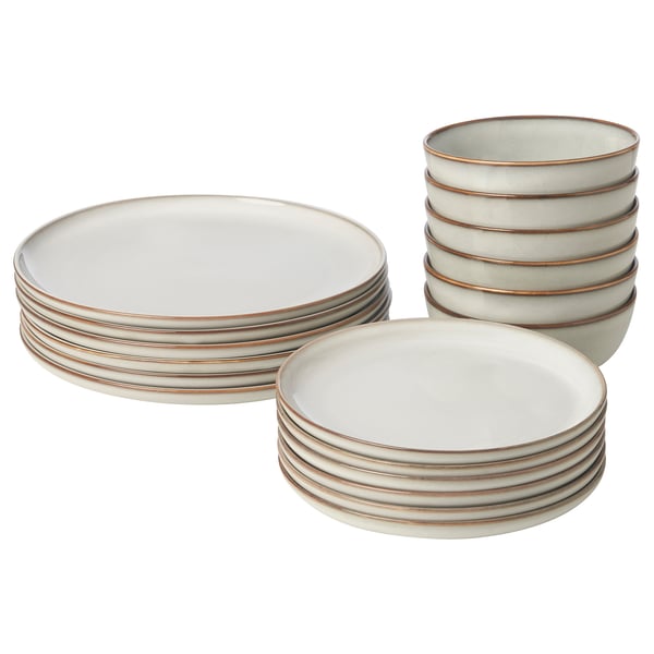 A stack of GLADELIG sandy-colored plates and bowls, made of stoneware, with a classic and decorative design.