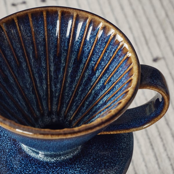 Crafted coffee dripper, blue glaze, ribbed interior, sturdy handle.