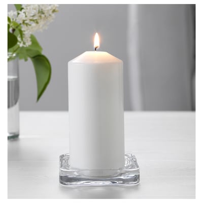 White candle in clear glass dish for ambience.
