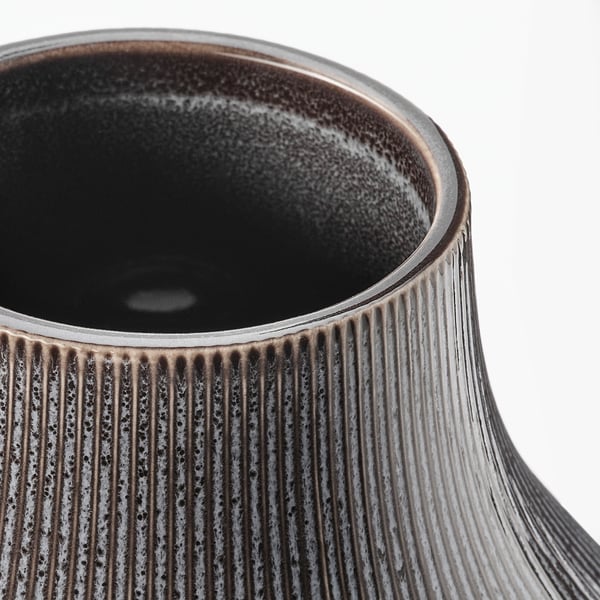 Dark brown vase, close-up with vertical grooves.