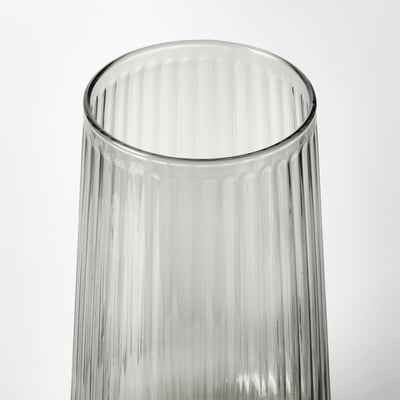 Clear glass vase with ribbed texture, standing upright against white background.