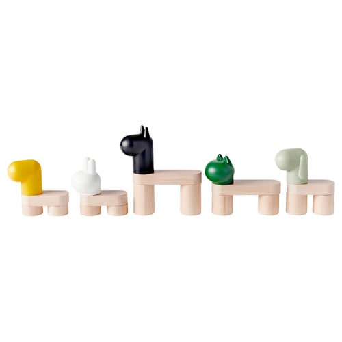 Five colourful toys: yellow, white, black, green, grey, on wooden stands.