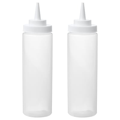 Two white squeeze bottles, empty, standing upright with caps on.