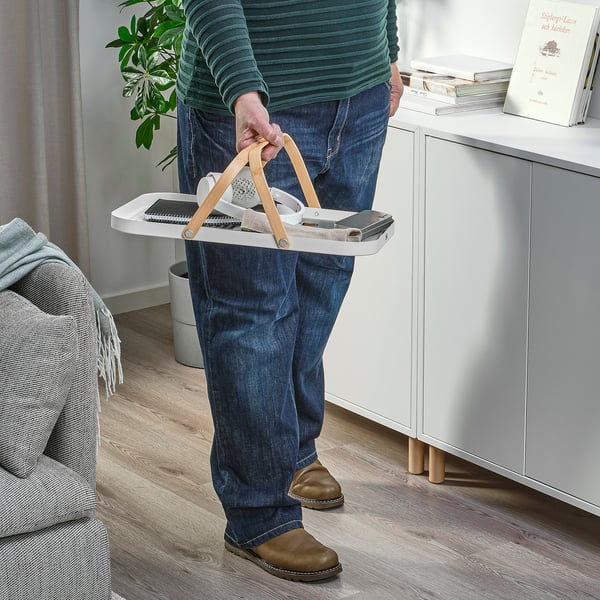 Person holding GRÖNFISK tray with items, showcasing its carrying handles and multi-use functionality.
