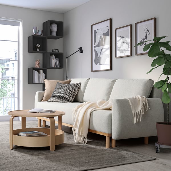 Modern living room with GRUNNARP sofa-bed, wooden coffee table, and stylish decor.