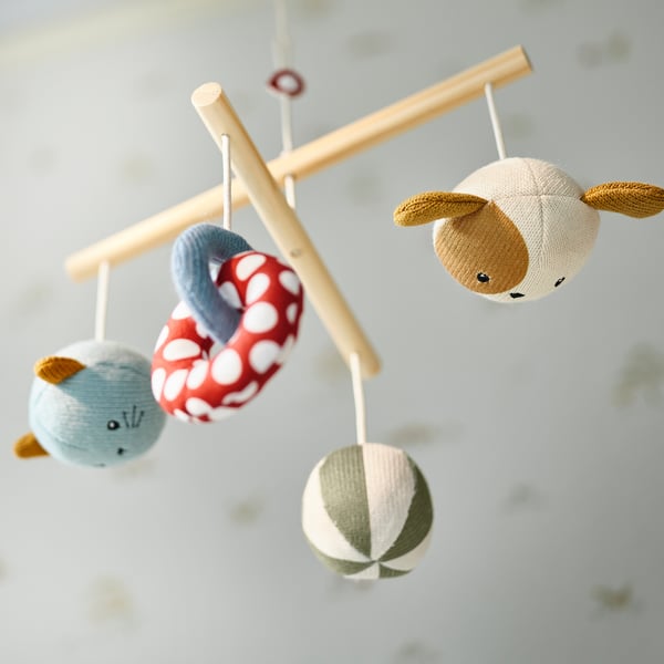Colourful baby mobile with animal figures hanging from wooden bars.