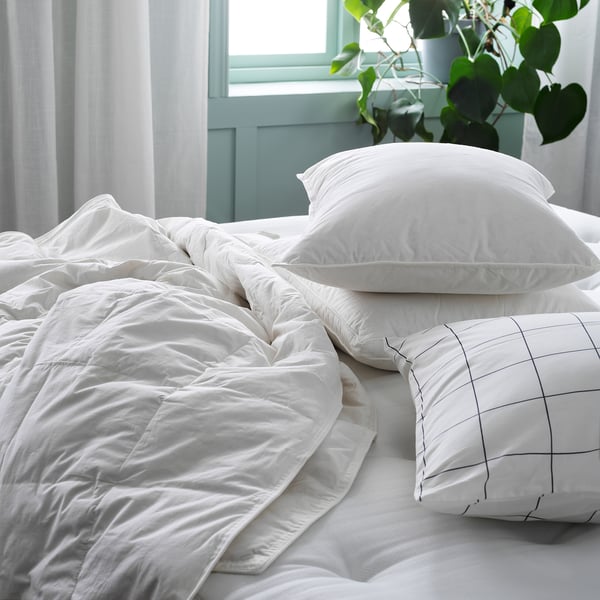 Unmade white bed with GULKAVLE pillows, soft & supportive, pure cotton & feather-filled.
