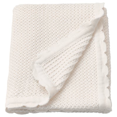 Folded white cotton baby blanket; soft, knitted with fringe edges.