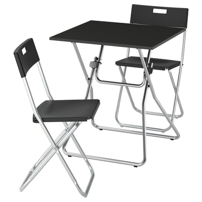 A GUNDE folding table and chair set in black with a metal frame, designed for easy storage and sturdy use.