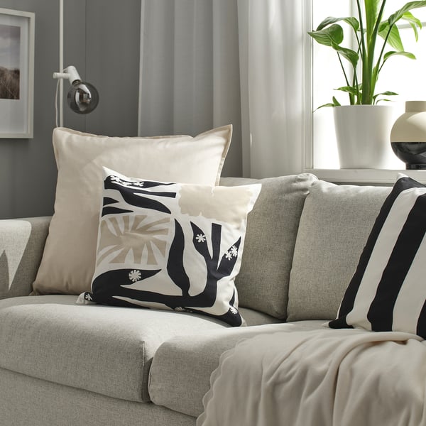 Grey couch with GURLI cushions and pillows, throw, plant.