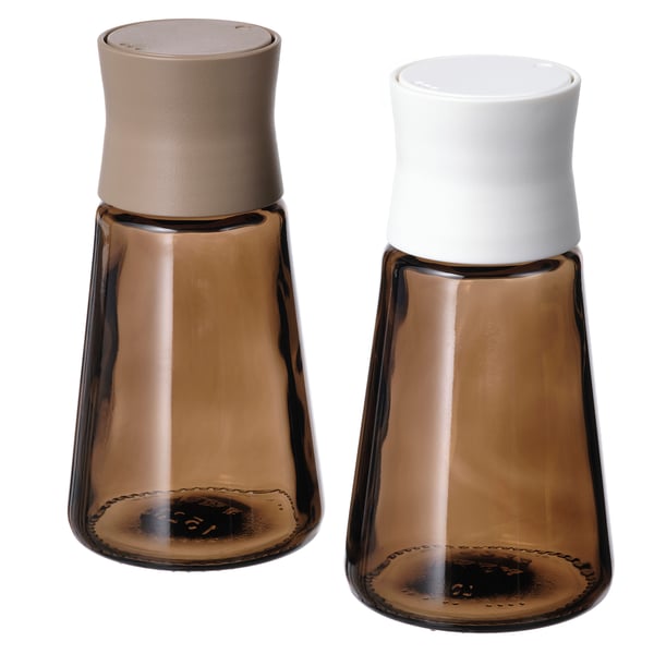 Pair of brown glass spice jars with white and beige lids, tapered shape, trendy design.