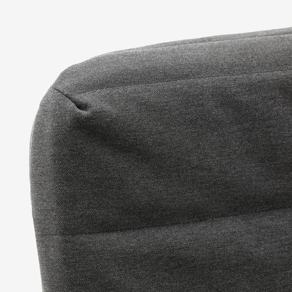 Grey upholstered sofa corner with smooth fabric, showcasing a modern and clean design.