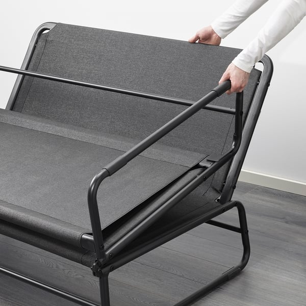 Person adjusts HAMMARN sofa beds backrest, converting it from seating to sleeping position.