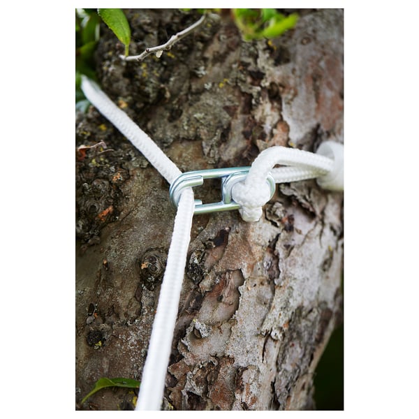 A white hammock strap attached to a tree trunk using a galvanised metal hook. The strap is secured with a knot.