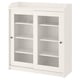 This image displays a white HAUGA cabinet with glass doors, ideal for displaying items. It has a classic design with a top shelf and sliding doors.