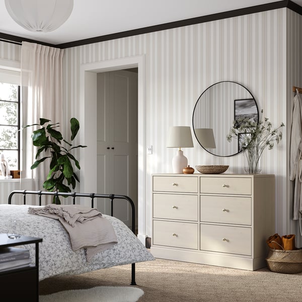 Bedroom with light-colored HAVSTA chest next to metal bed, six drawers, minimalist design.