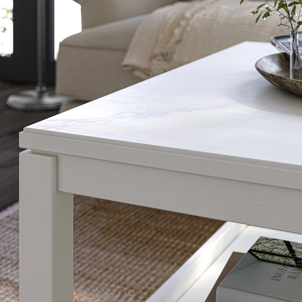 White coffee table in living room; minimalist, rectangular design with one visible shelf.
