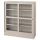 HAVSTA light wood cabinet with glass doors and shelves.