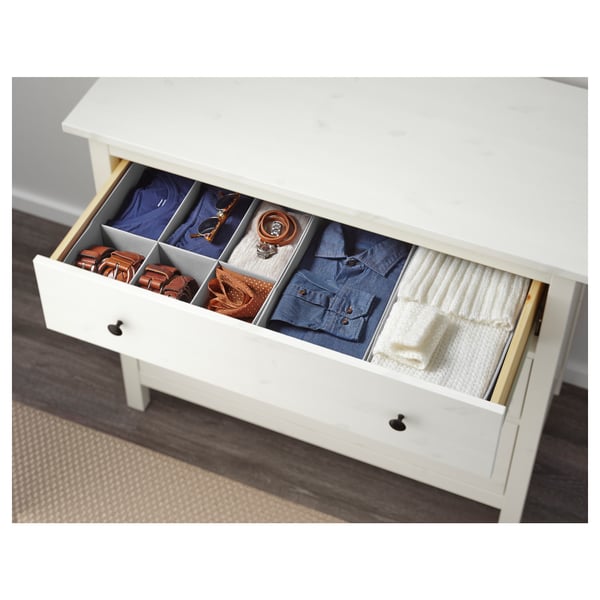 Open drawer showing neatly folded clothes and accessories, demonstrating organised storage.