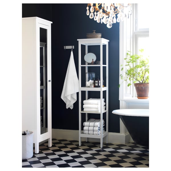 Elegant bathroom with white HEMNES shelves and dark wall, black-and-white chequered floor, and potted plant.
