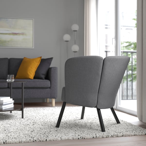 Grey armchair with flower design near window.