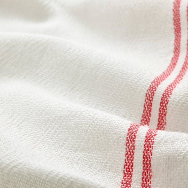 Close-up of neatly folded white cloth with red stitching, showcasing premium quality fabric and detailed craftsmanship.