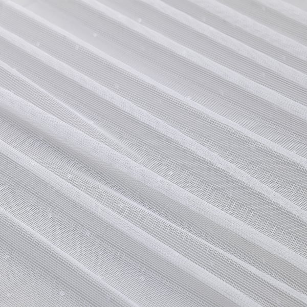 Sheer, white curtains with diagonal folds, likely made of recycled polyester, offering privacy while allowing light to pass through.