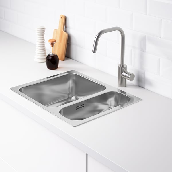 Stainless steel double basin sink with modern tap; one large, one small bowl, ideal for multitasking.