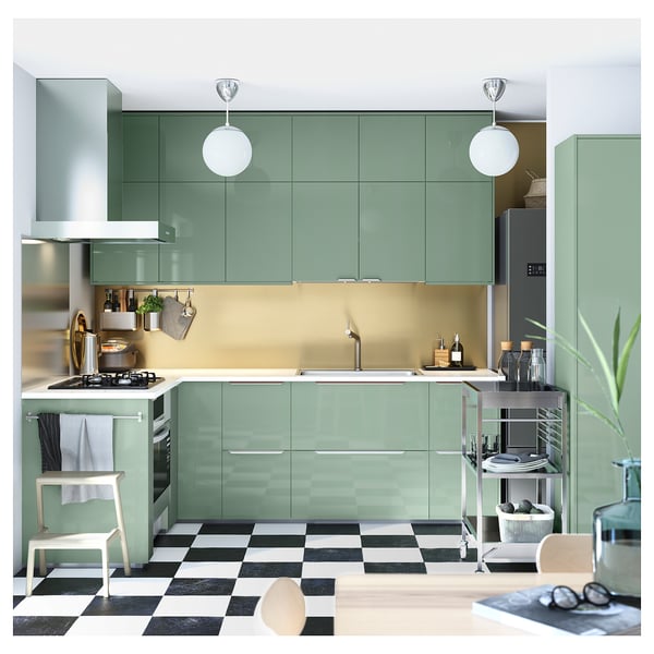 Modern kitchen: green cabinets, chequered floor, pendant lights, steel appliances, large sink.
