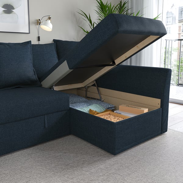 Sofa bed with storage. Lifted seat reveals hidden storage box filled with items.