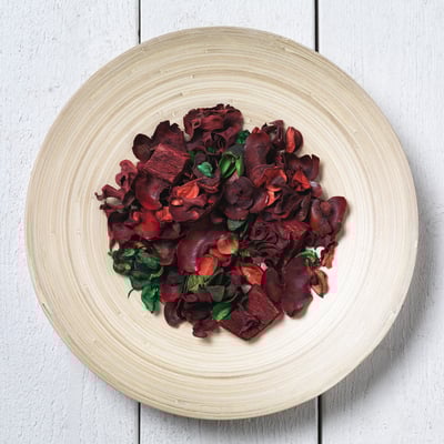 Round wooden plate with red chips and herbs. Handmade, smooth finish.