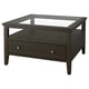 The IDANÄS dark brown coffee table with a glass top and wooden frame, featuring a single drawer for storage.