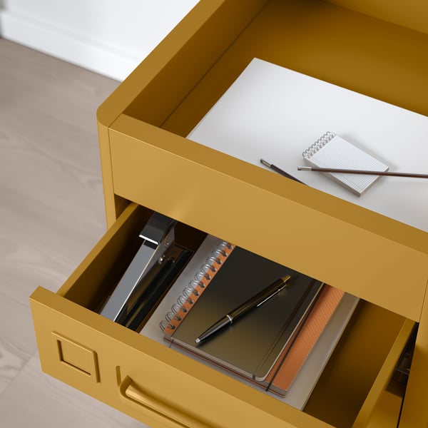Mustard yellow office drawer unit with open compartments. Displayed items include notebooks and pens, showcasing built-in organisation.