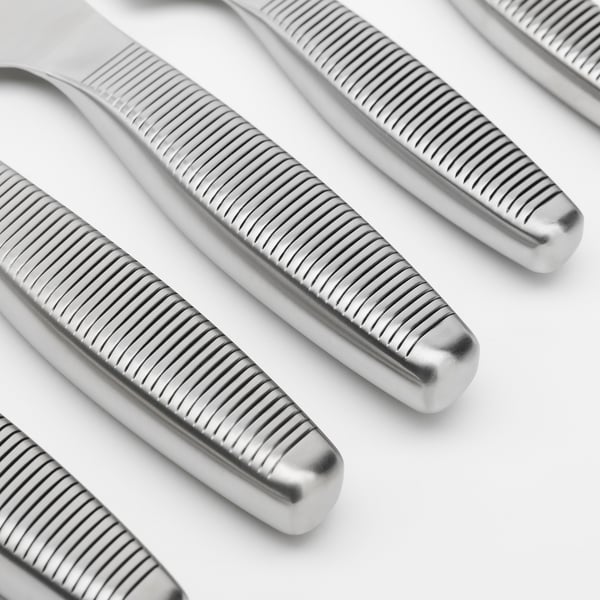 Close-up of polished, stainless steel knives; sleek, grooved handles detailed.