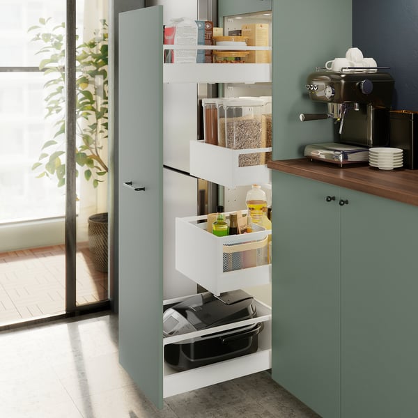 Kitchen cabinet with pull-out shelves holding pantry items like grains, bottles, and a coffee machine.
